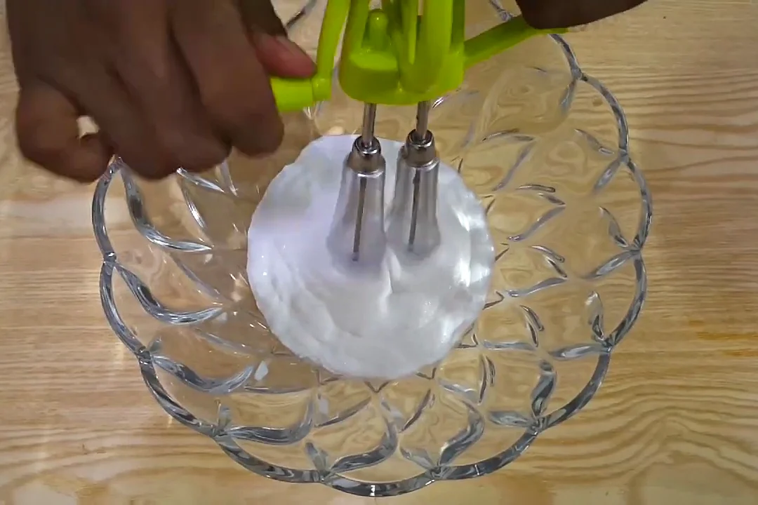 Beating whipping cream with a hand beater