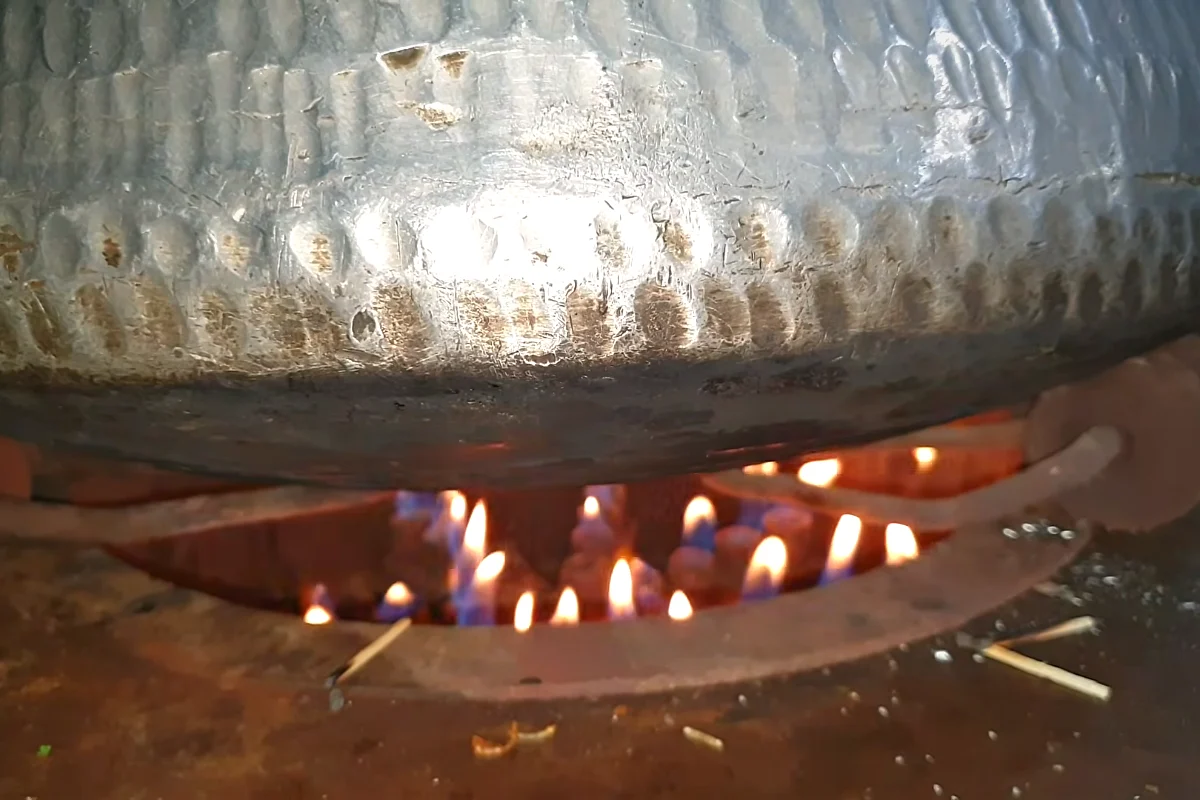 Covered biryani deg on a low flame for dum