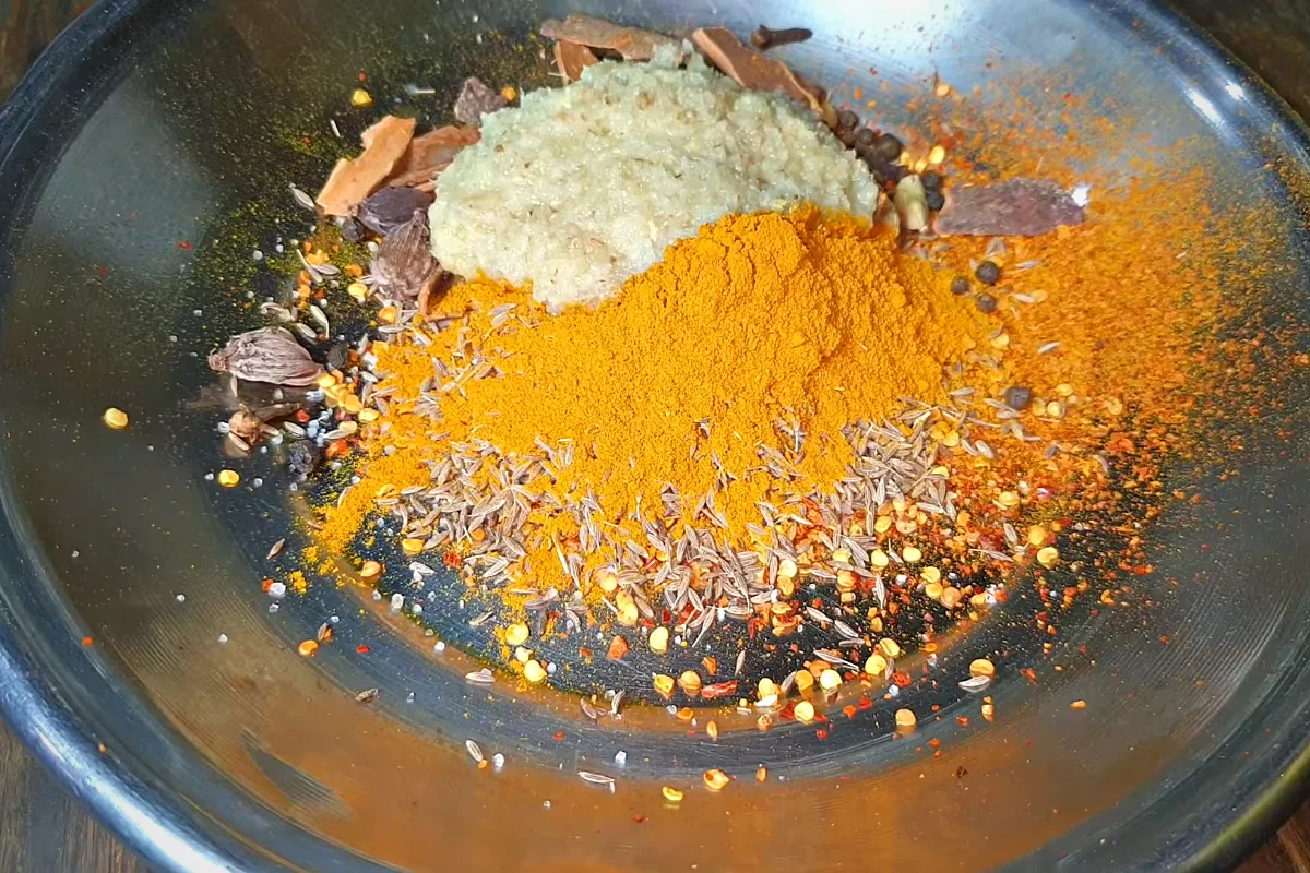 Biryani spices on a tray: red chilli flakes, cumin, turmeric, black pepper, cardamom, cinnamon and ginger garlic paste