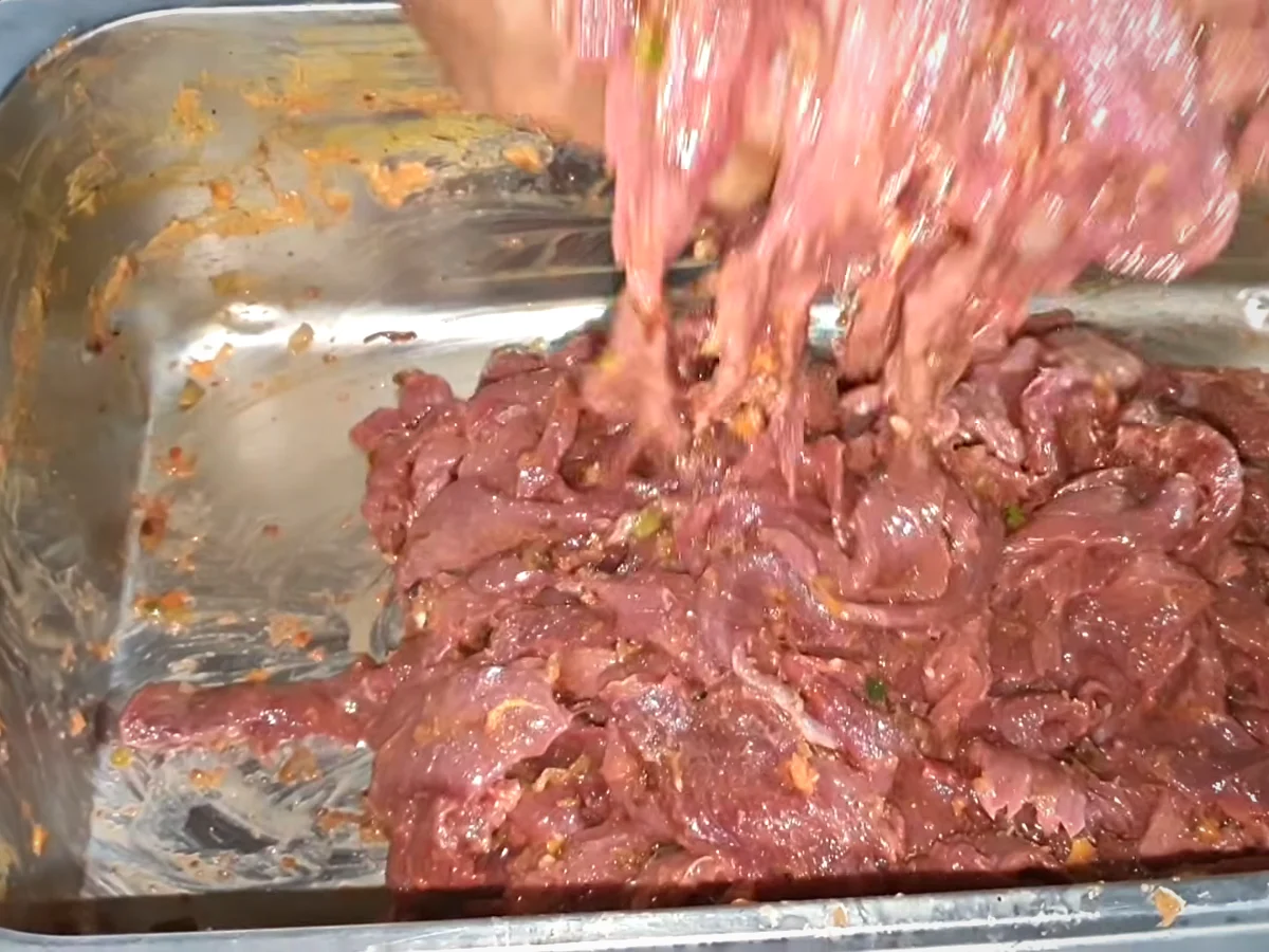 Pasanda cut beef strips being mixed with browned onion