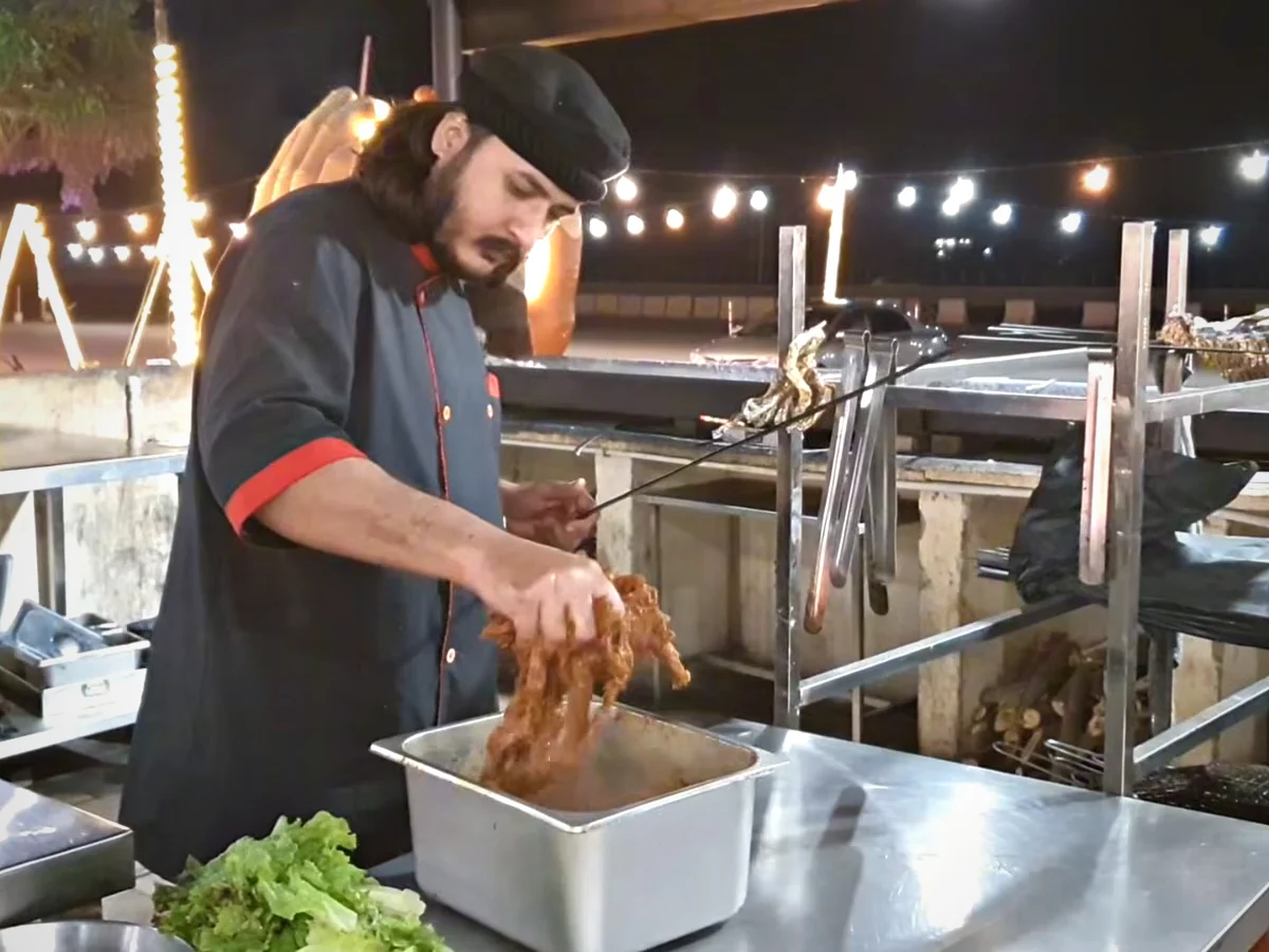 Chef threading marinated beef onto skewers at Dua Restaurant