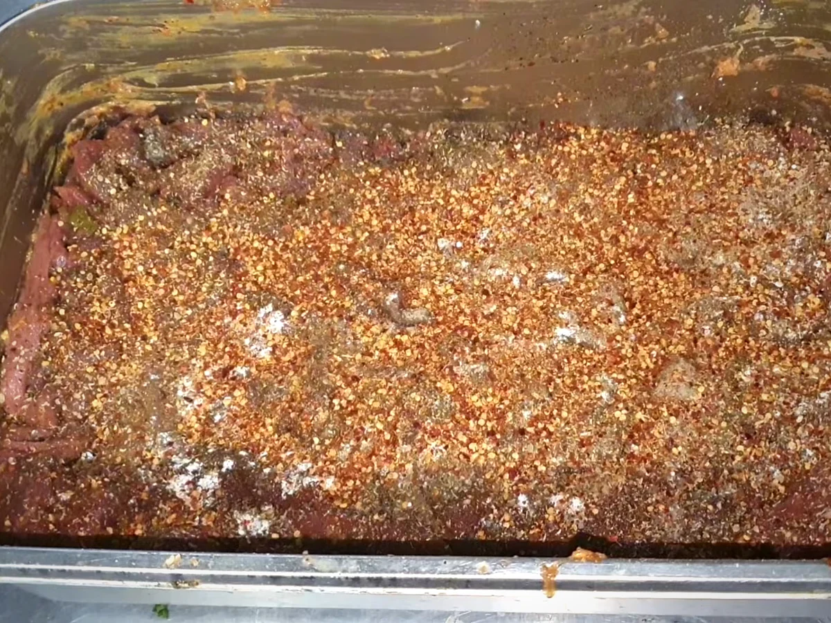 Layers of ground spices and chilli flakes over beef for bihari boti