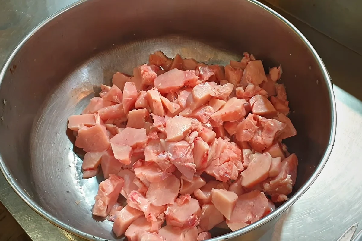 Boneless chicken cubes in a large pot for reshmi kabab