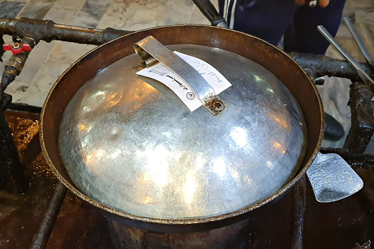 Covered karahi with mutton cooking in hot water
