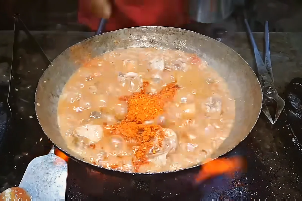 Crushed red chilli added to chicken karahi