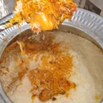 Degi chicken biryani with orange and white rice being served from the deg