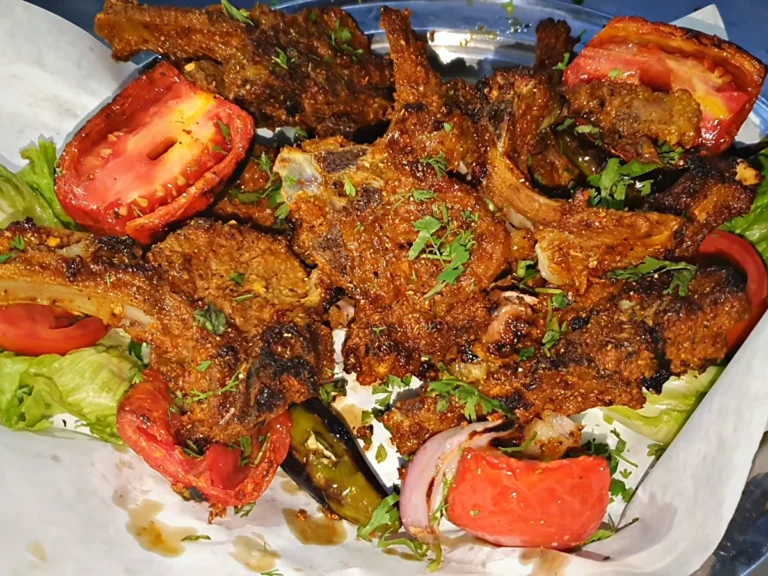 Dua Restaurant chatpata mutton chops BBQ plated with tomato, lettuce, green chilli and coriander