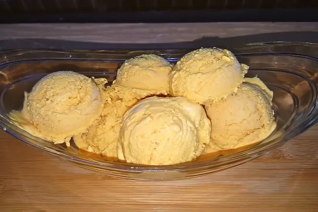 Scoops of homemade mango ice cream in a glass bowl
