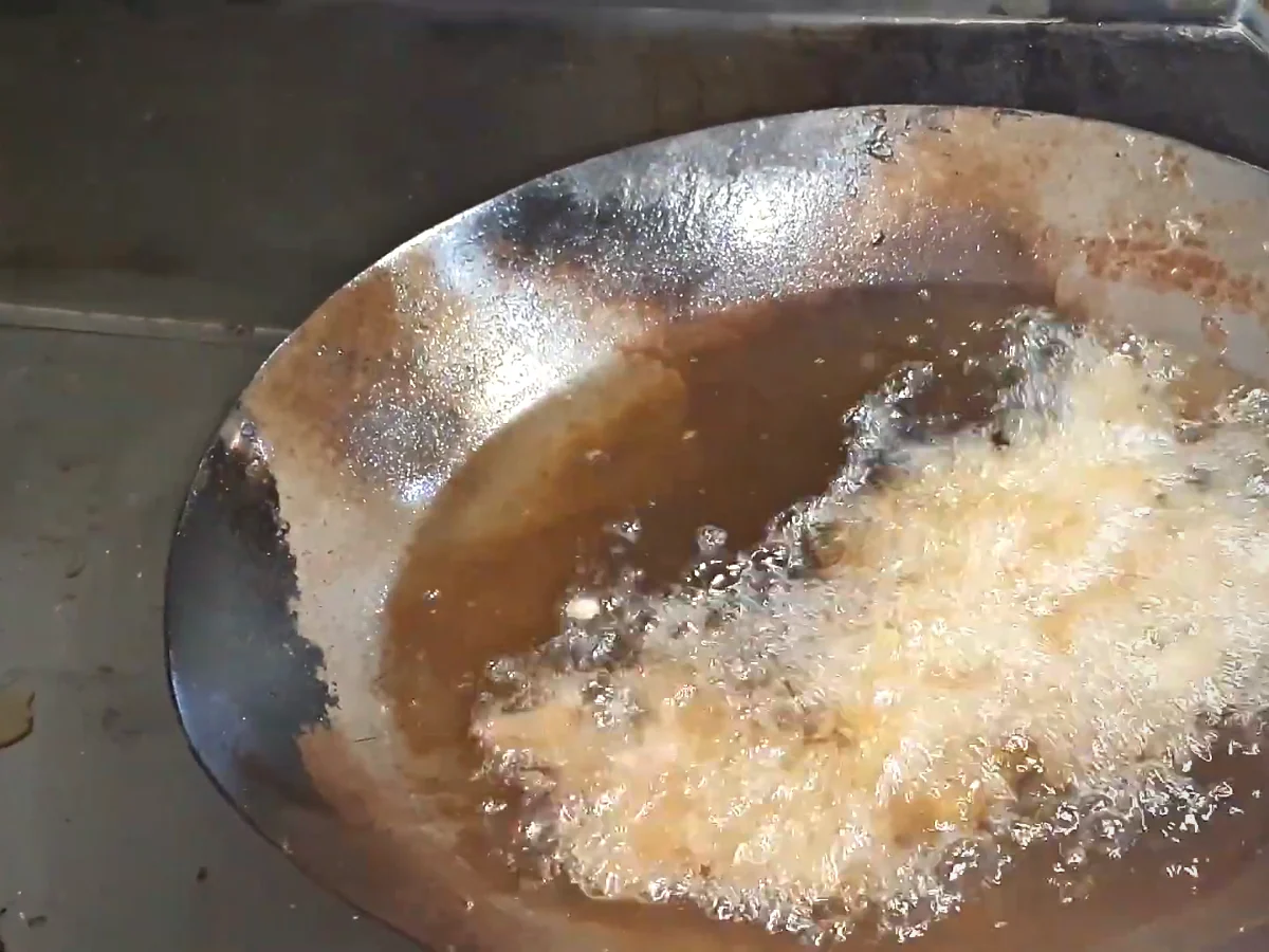 Coated beef strips frying in oil for beef chilli dry