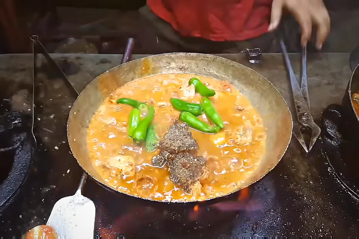 Whole green chillies added to chicken karahi with spices