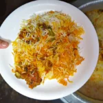 Plate of Karachi raseeli beef biryani with yellow and white rice, beef and potato