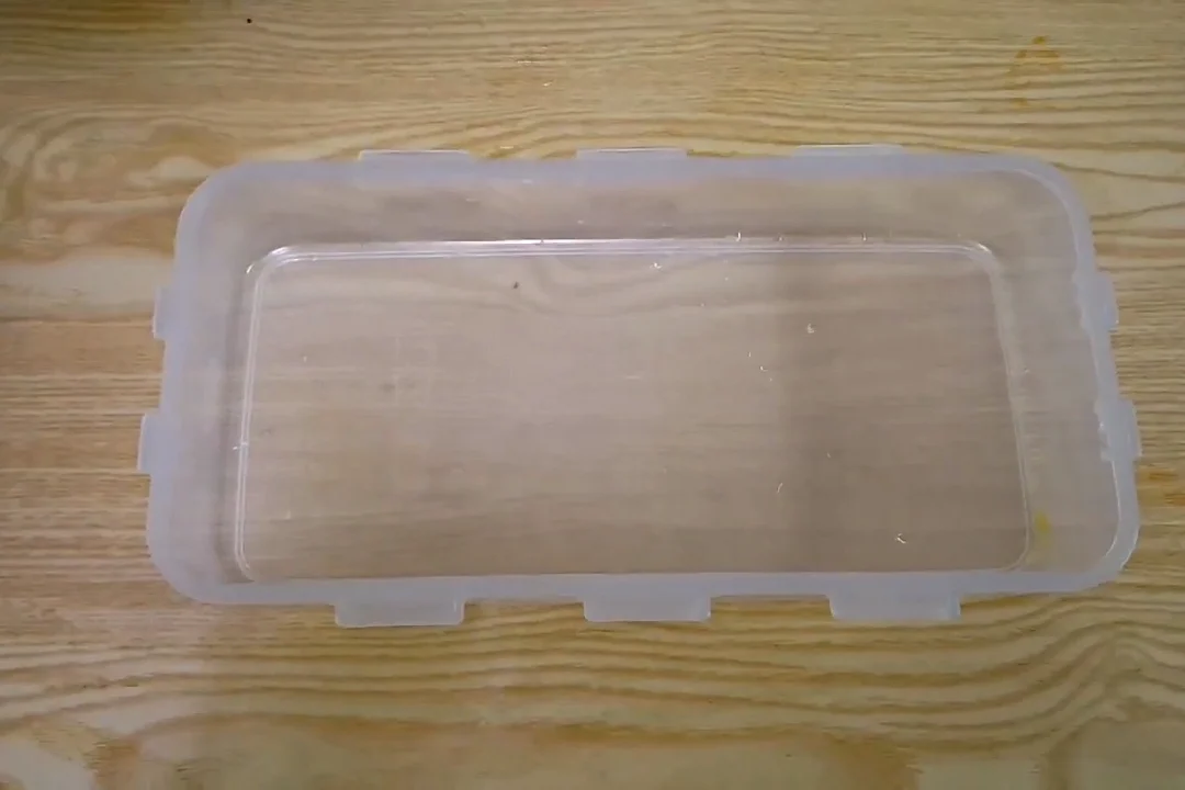Mango ice cream mixture poured into an airtight box