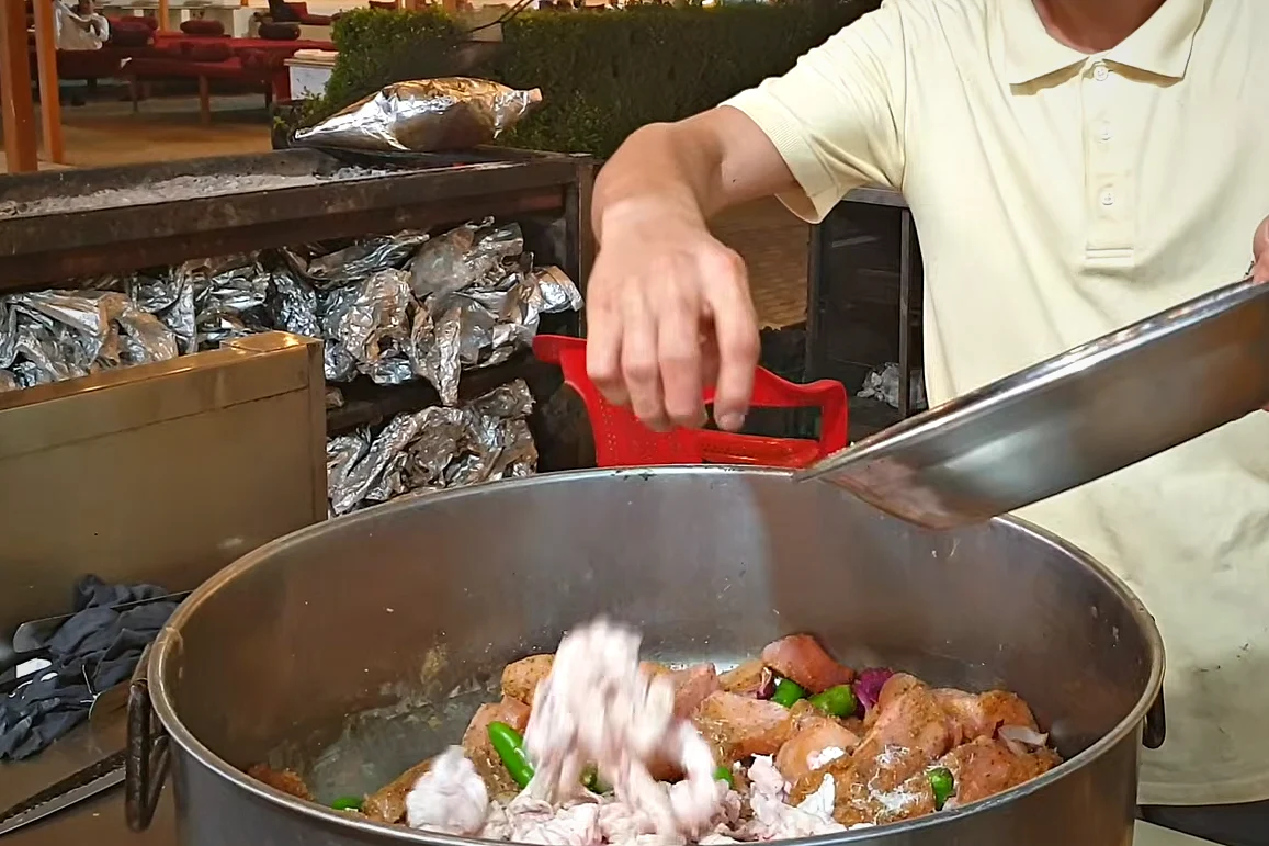 Chicken, onion, green chillies and white chicken fat being mixed before mincing