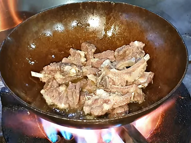 Boiled mutton chops browning in the karahi