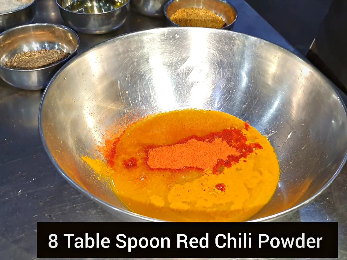 Red chilli powder added over turmeric and tandoori masala in the marinade bowl