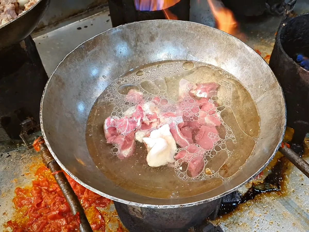 Hot water added to mutton in a handi before covering