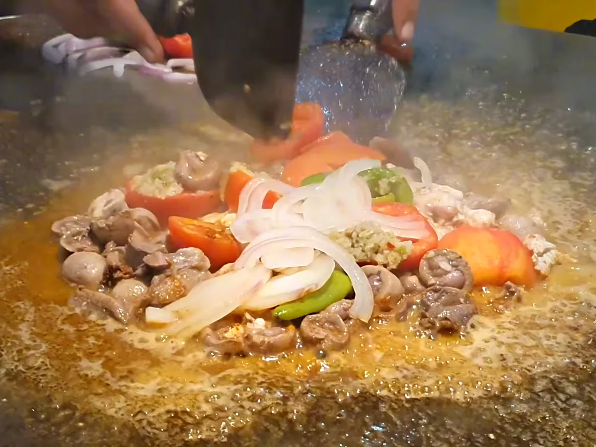 Sliced onion and hot water added to kata kat on the tawa