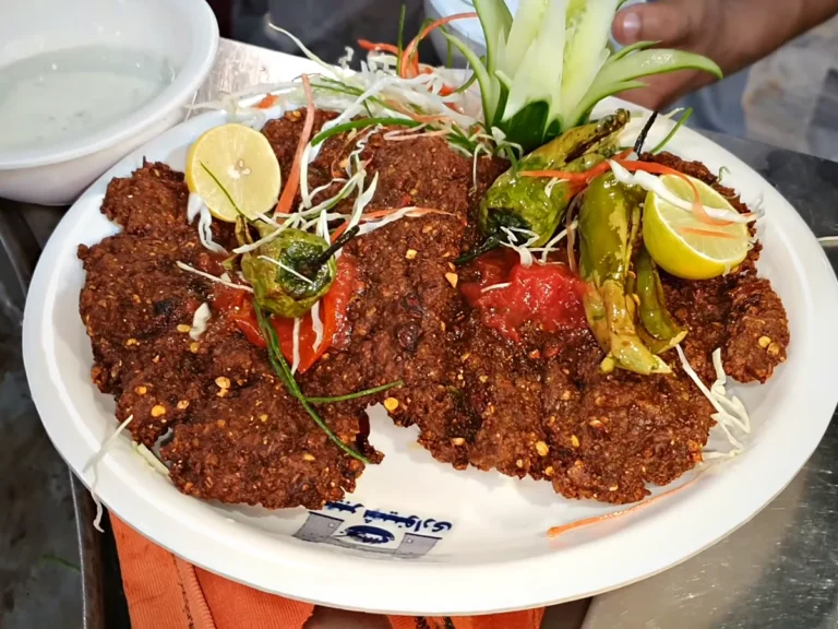 Peshawari chapli kabab plate with fried tomato, green chillies and lemon at Khyber Shinwari