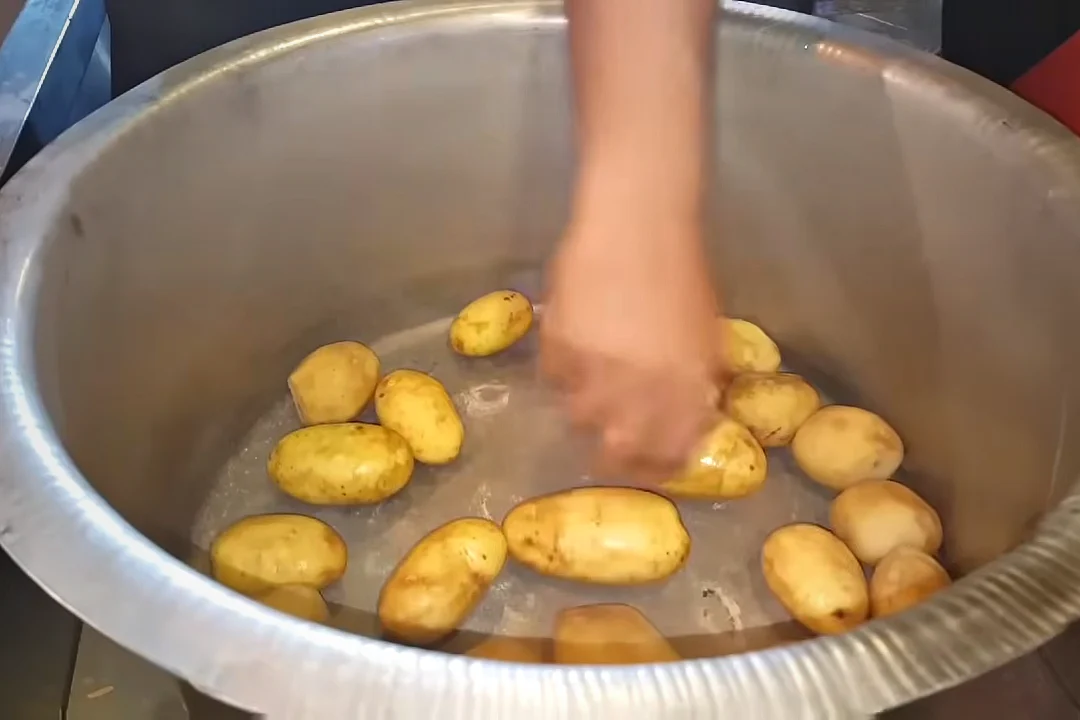 Whole peeled potatoes placed at the bottom of the pot for mutton rosh