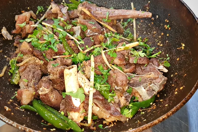 Sulemani mutton karahi with ginger, green chillies and coriander in a black karahi