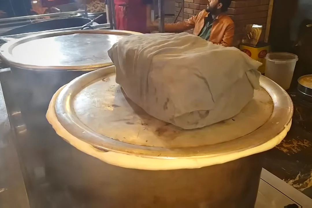 A heavy weight wrapped in cloth on the sealed lid of the rosh pot