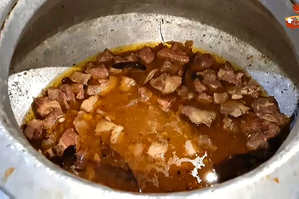 Tender beef pieces in glossy yakhni after about 1.5 hours of slow cooking