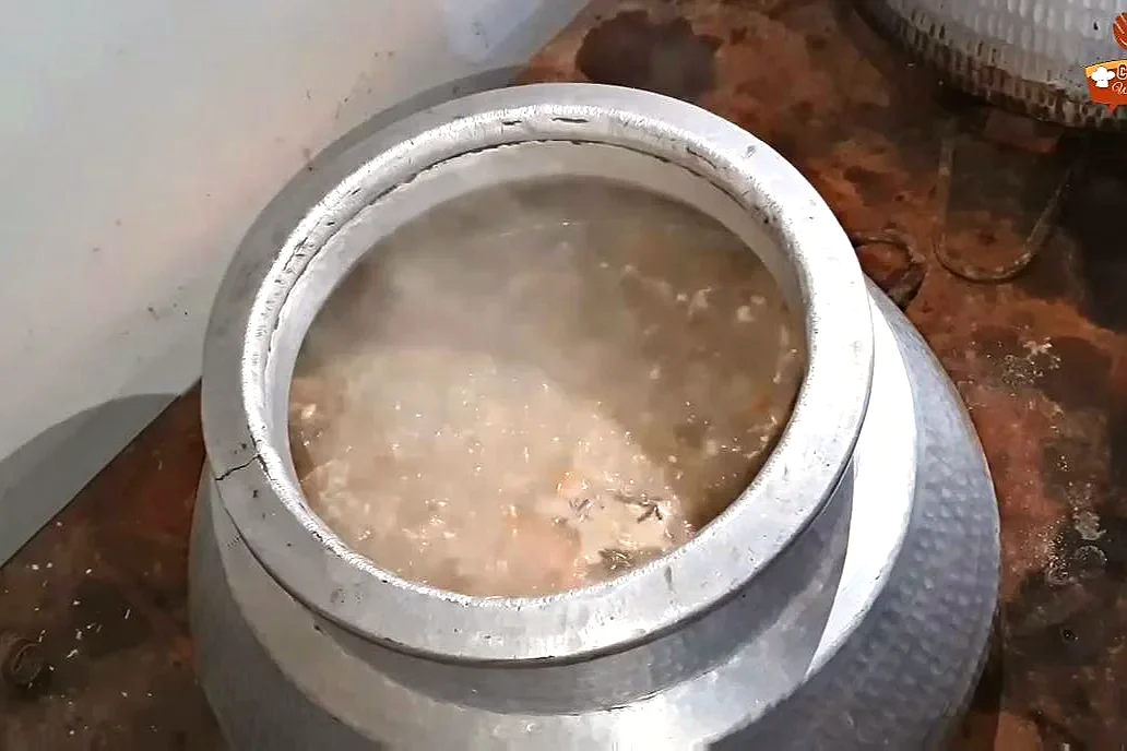 Beef yakhni boiling in the deg with yogurt, oil and water
