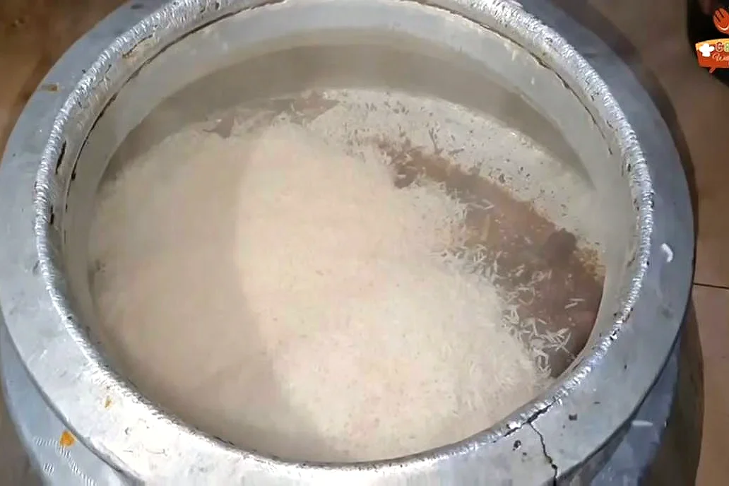 Par-boiled basmati rice layered over the beef masala in the deg