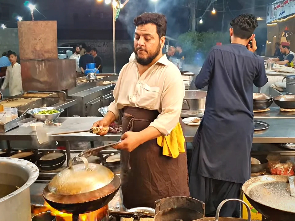 Cooks at the karahi station of Yadgar Shinwari Restaurant