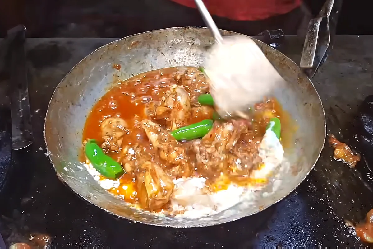 Yogurt stirred into chicken karahi at the end