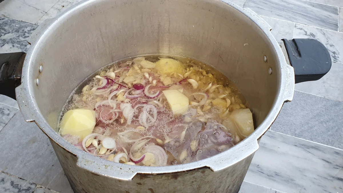 Mutton, sliced onions and water in a pressure cooker before it is closed