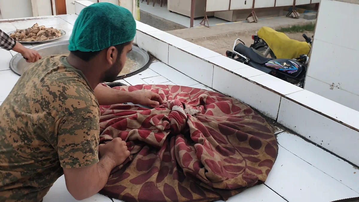 Cook covering the deg with a thick patterned cloth for dum