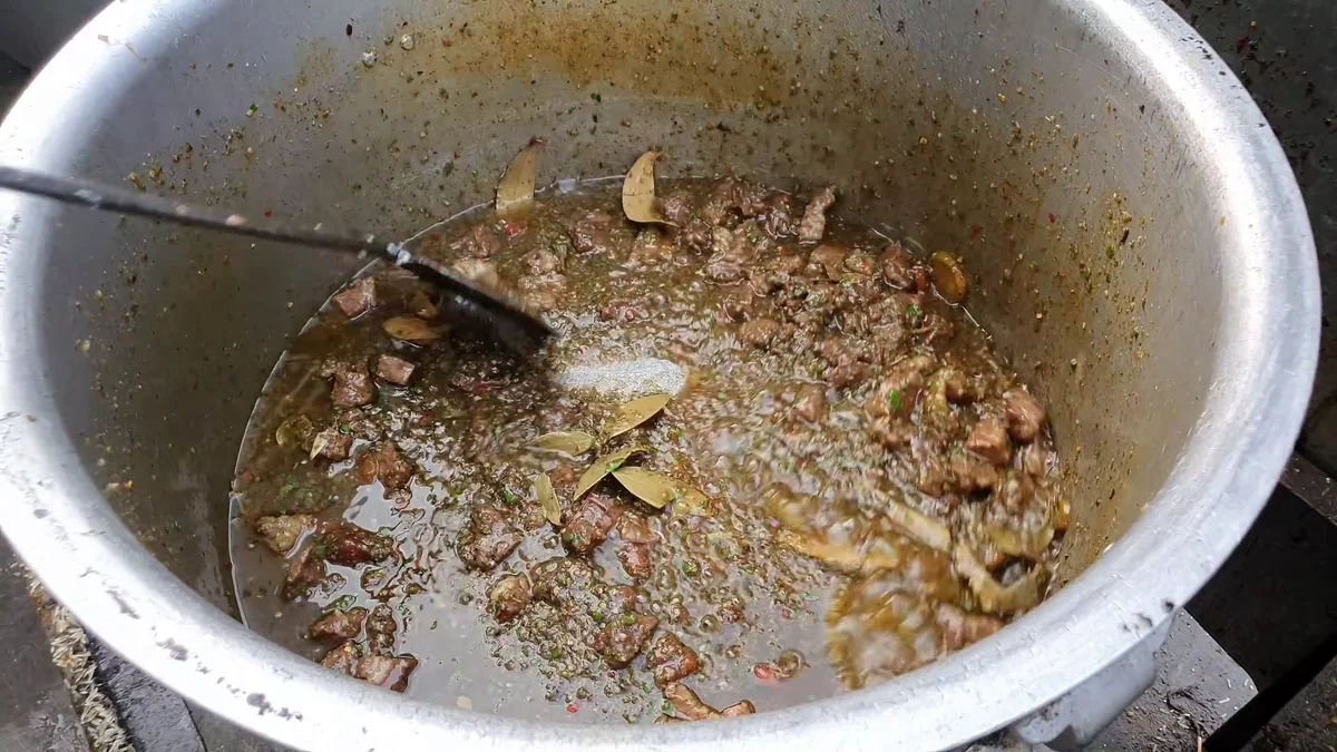 Beef cooking with bay leaf and whole spices in the pot