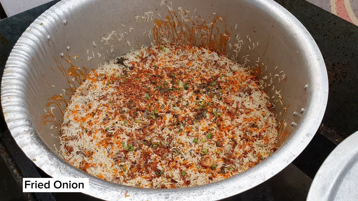 Fried onion and orange colour over the cooked rice before the final dum