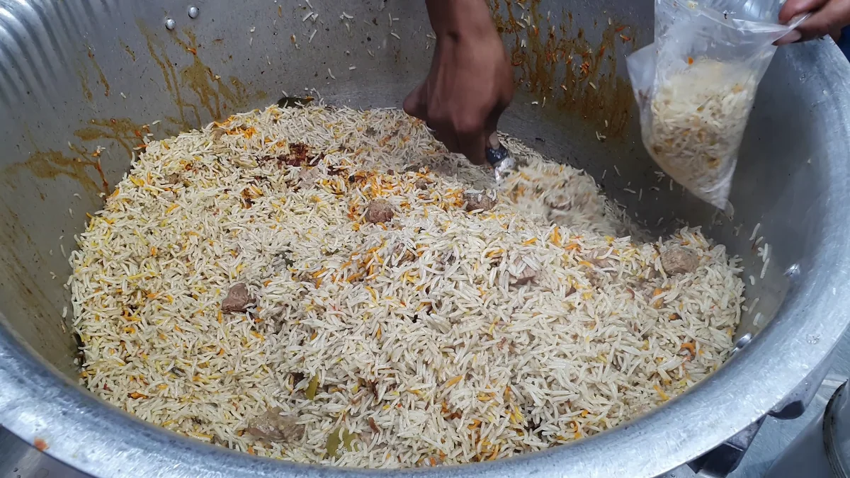 Beef pulao being mixed gently from the sides after dum