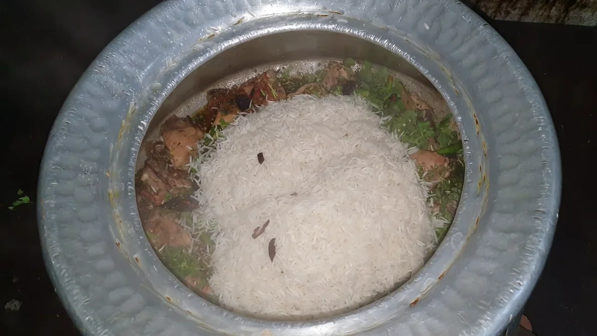 Rice layered over the chicken in the deg