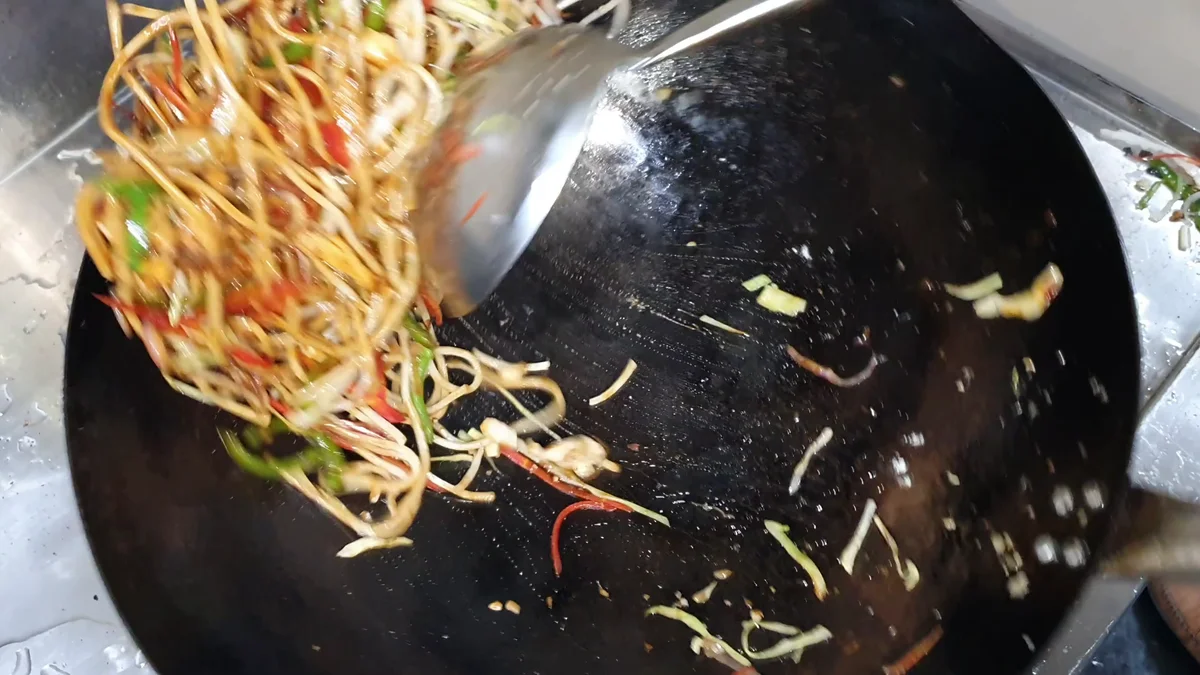 Noodles tossed high in the wok