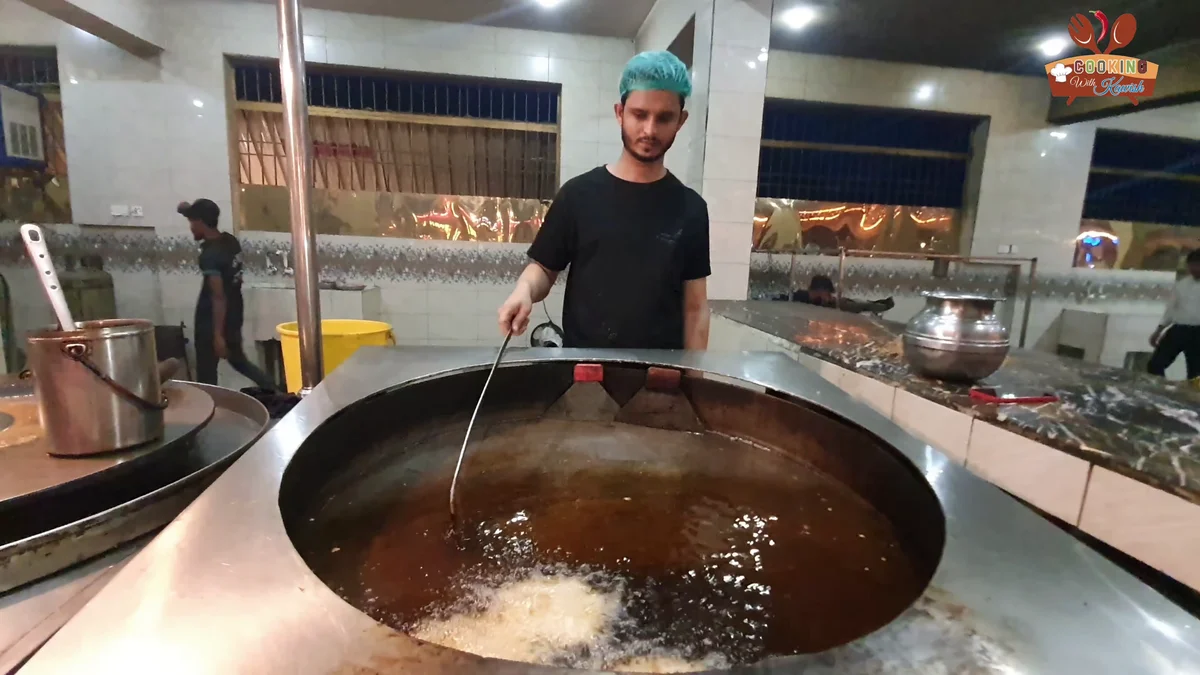 Chapli kababs frying in a wide pan of oil