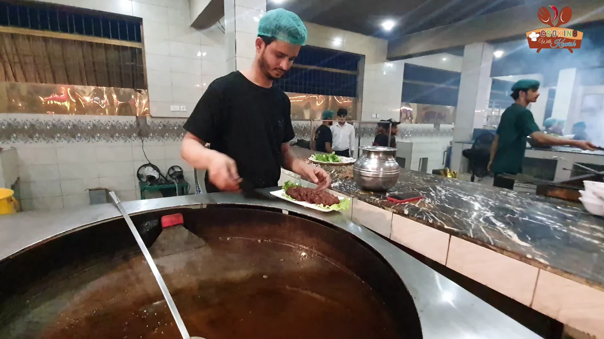 Cook lifting fried chapli kababs out of the pan