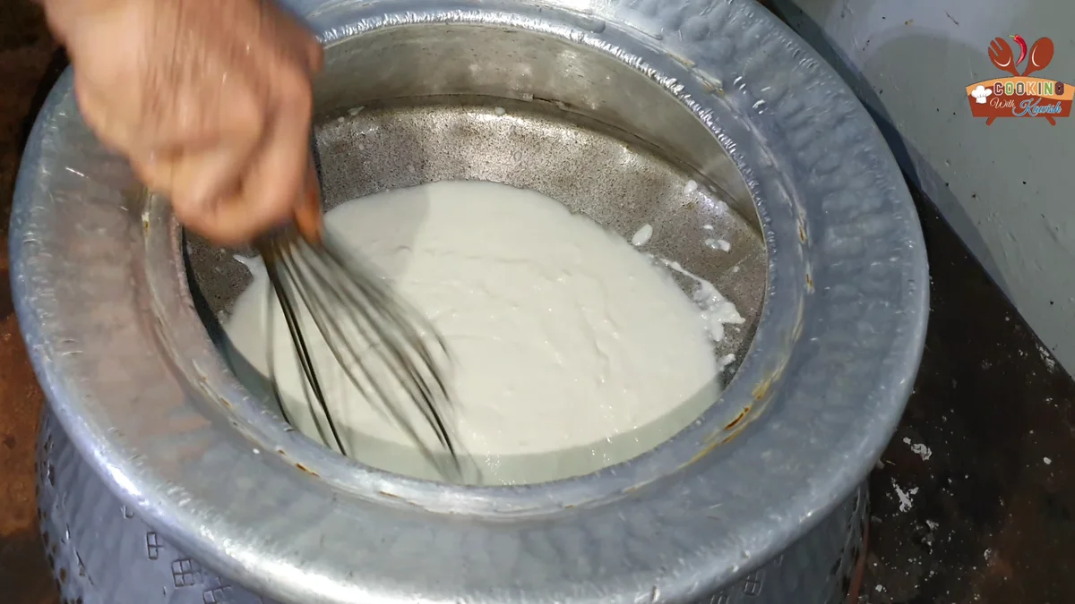 Whisking the yogurt in a large deg