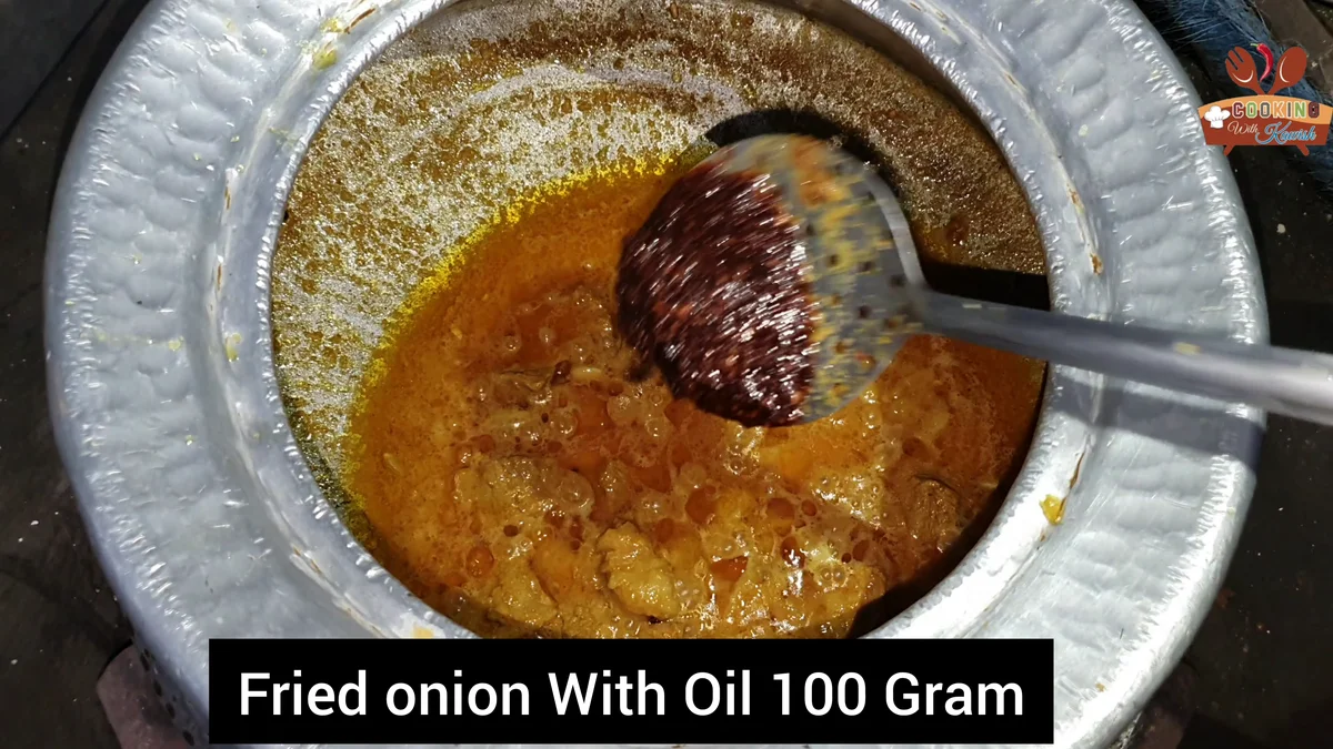 Fried onion with oil being added to the korma