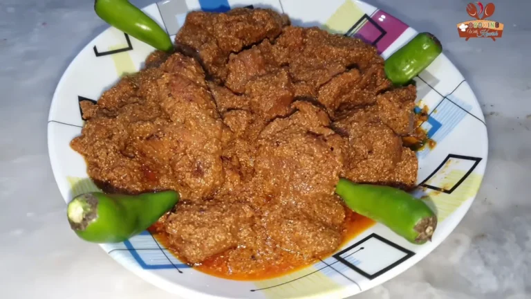 Bihari beef pasanday on a plate with green chillies