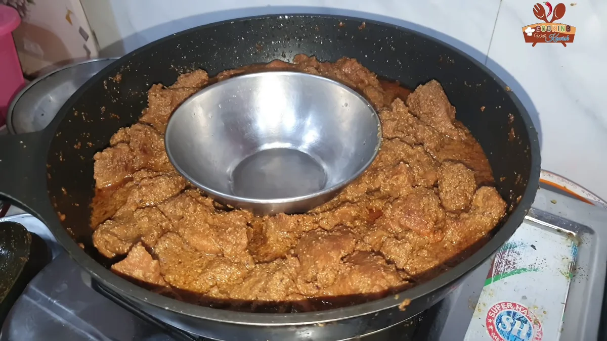 Steel bowl with hot charcoal set in the middle of the pasanday