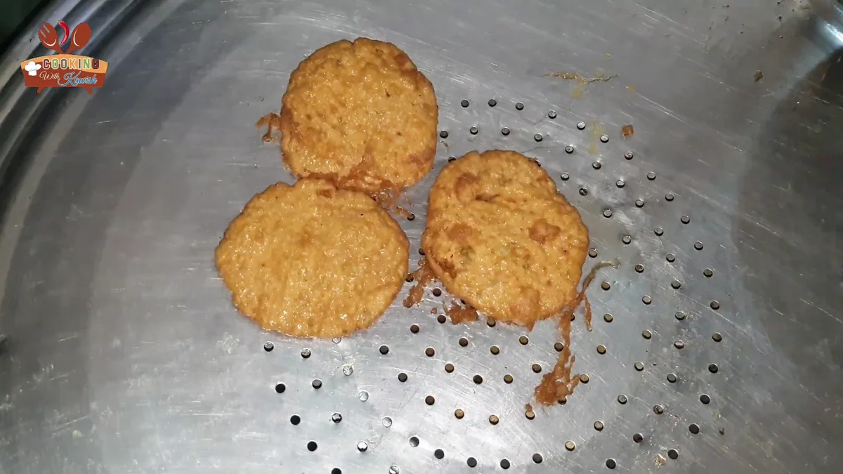 Three golden fried Bohra chicken cutlets on a strainer