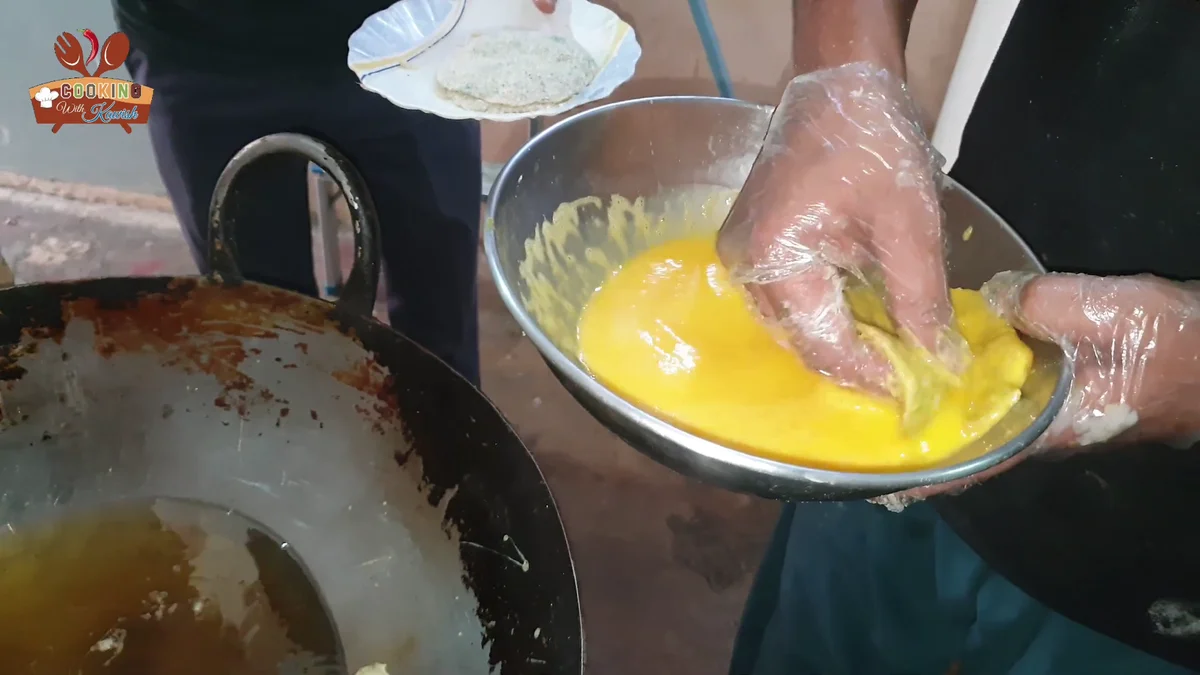 Dipping a cutlet into beaten egg