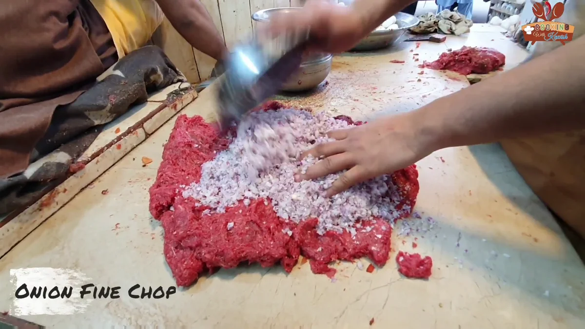 Onion mixed into the minced meat on a wooden board