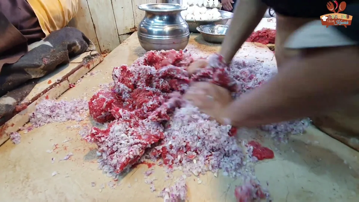 Mixing the chopped onion into the mince by hand
