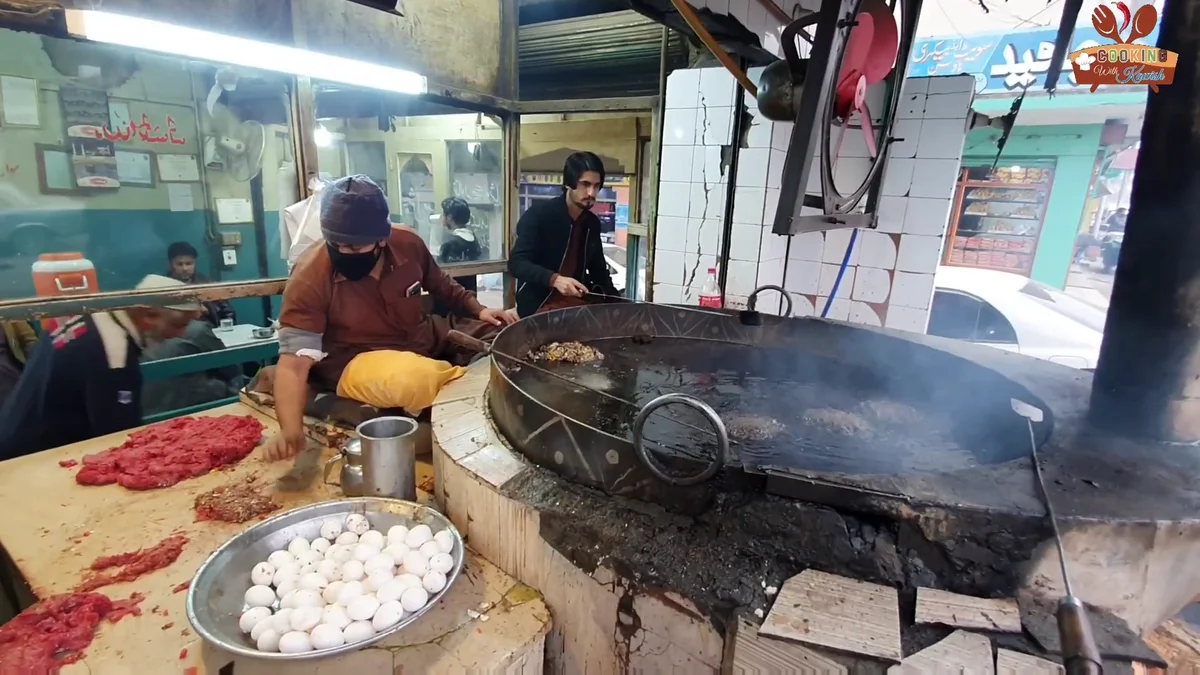 Cook placing kababs into the hot fat