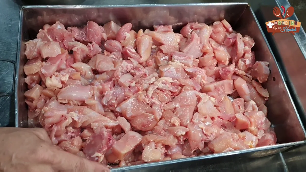 Boneless chicken pieces in a large steel tray for reshmi kabab