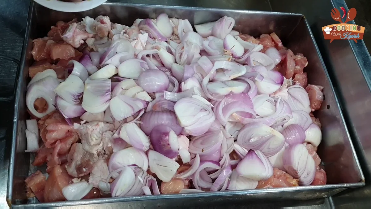 Roughly chopped onions spread over the chicken and fat